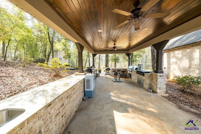 view of patio featuring exterior kitchen, a grill, and ceiling fan