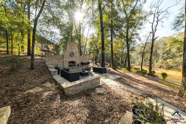 view of yard featuring a patio and an outdoor fireplace