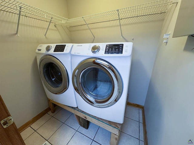 clothes washing area with washing machine and dryer and light tile patterned flooring