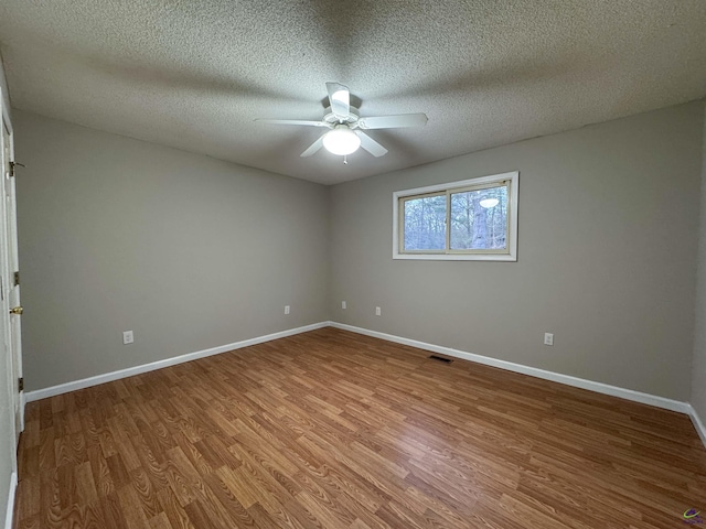 unfurnished room featuring ceiling fan, wood-type flooring, and a textured ceiling