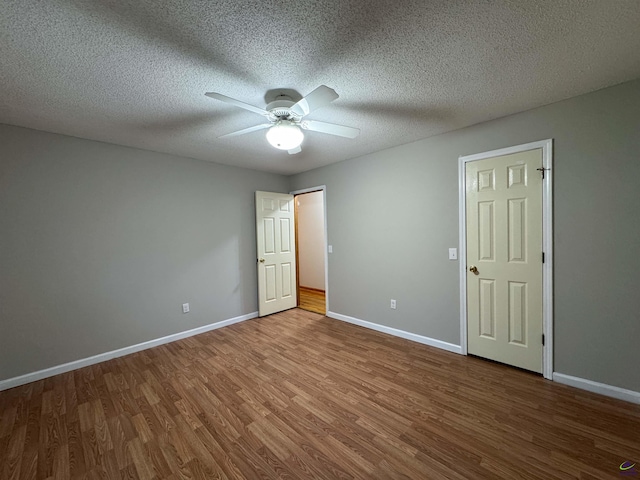 unfurnished bedroom featuring ceiling fan, a textured ceiling, and hardwood / wood-style flooring