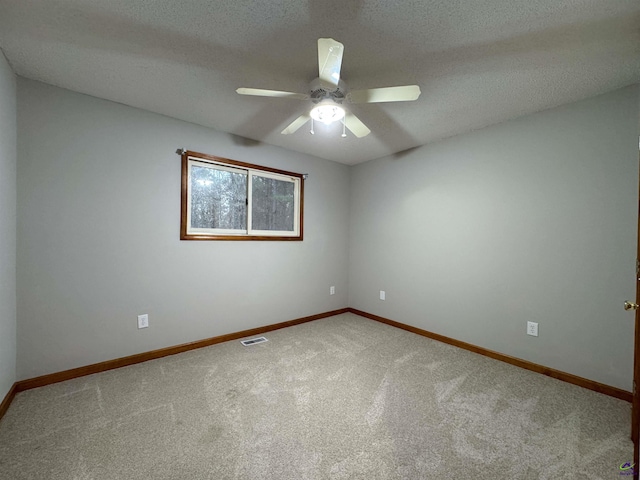 empty room featuring a textured ceiling, ceiling fan, and carpet floors