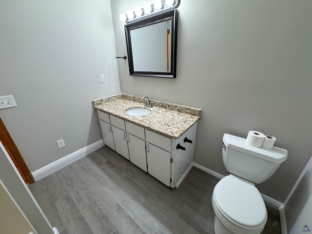 bathroom with hardwood / wood-style floors, toilet, and vanity