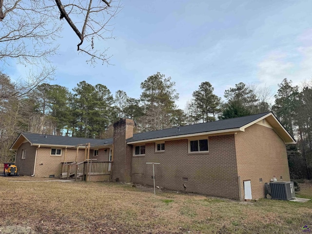 rear view of house with a wooden deck, central AC, and a yard