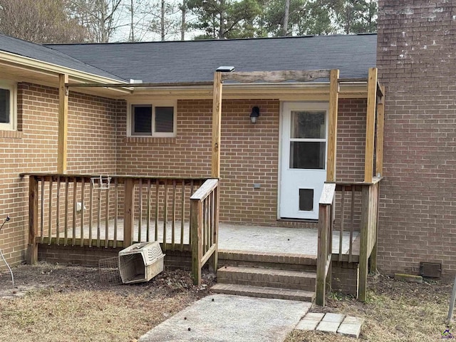 view of exterior entry with a deck