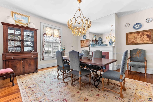 dining area featuring an inviting chandelier, ornamental molding, and light hardwood / wood-style flooring