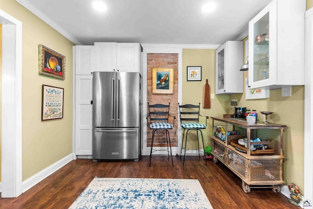 kitchen with white cabinetry, ornamental molding, dark hardwood / wood-style flooring, and high end refrigerator