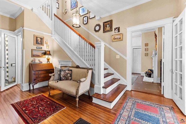 staircase with crown molding and hardwood / wood-style floors