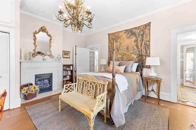 bedroom with a chandelier, crown molding, a fireplace, and hardwood / wood-style flooring