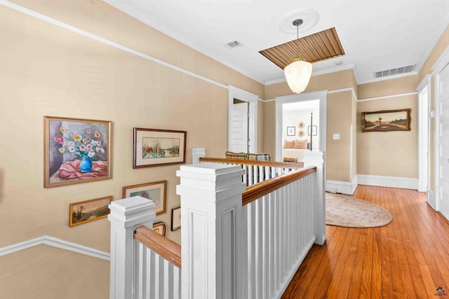 hall with ornamental molding and hardwood / wood-style flooring