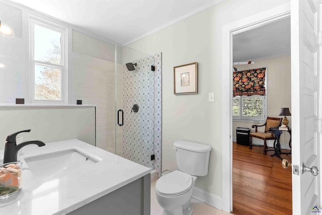 bathroom with toilet, vanity, hardwood / wood-style flooring, a shower with shower door, and ornamental molding