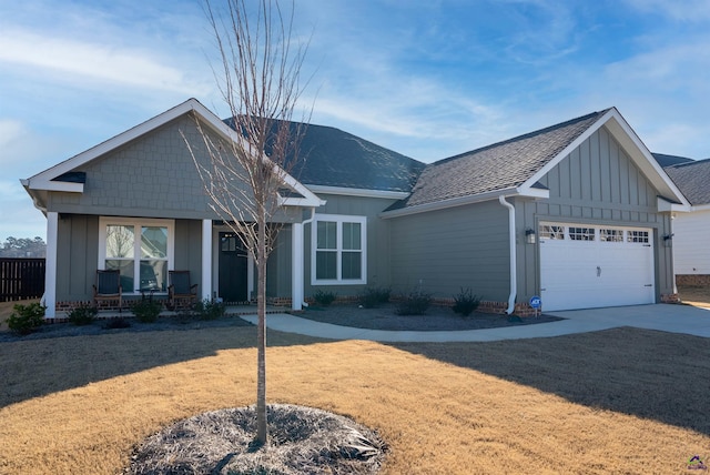 view of front of house featuring a front yard, covered porch, and a garage