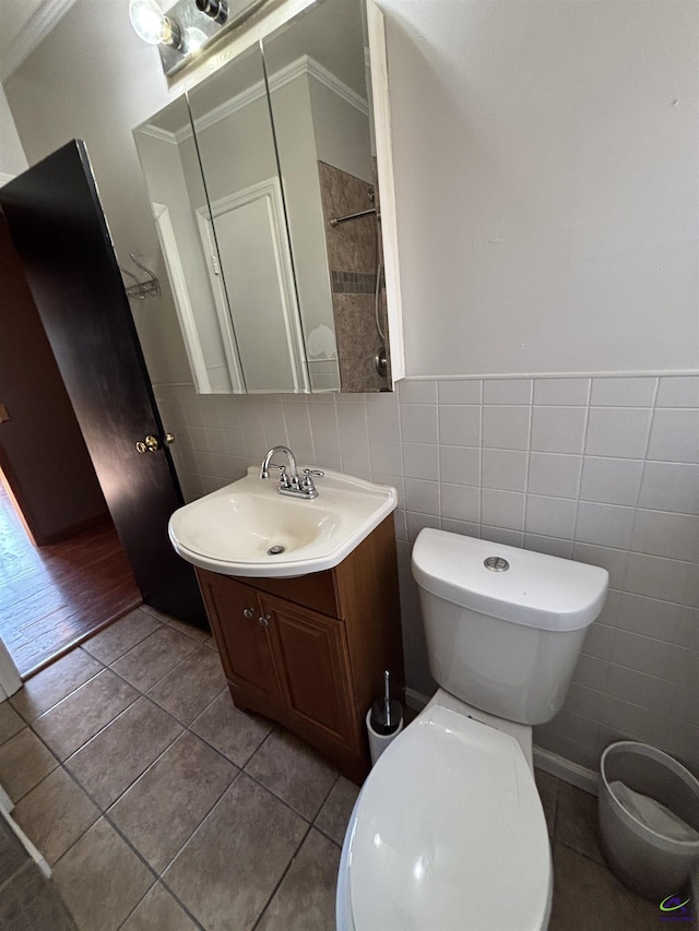 570 Perry Hwy, Hawkinsville, GA 31036 - bathroom with tile patterned flooring, vanity, tile walls, toilet, and ornamental molding