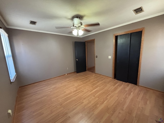 570 Perry Hwy, Hawkinsville, GA 31036 - unfurnished bedroom with ceiling fan, a closet, ornamental molding, and light hardwood / wood-style floors