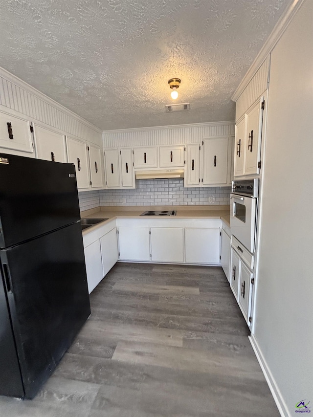 570 Perry Hwy, Hawkinsville, GA 31036 - kitchen featuring white cabinetry, dark hardwood / wood-style flooring, and white appliances