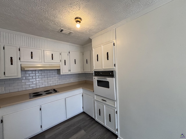 570 Perry Hwy, Hawkinsville, GA 31036 - kitchen featuring backsplash, white appliances, dark hardwood / wood-style flooring, ornamental molding, and white cabinets
