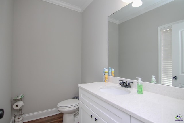 bathroom featuring toilet, crown molding, wood-type flooring, and vanity