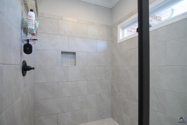 bathroom featuring ornamental molding and a tile shower