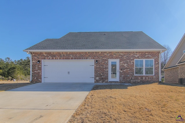 view of front of house with a garage and central air condition unit