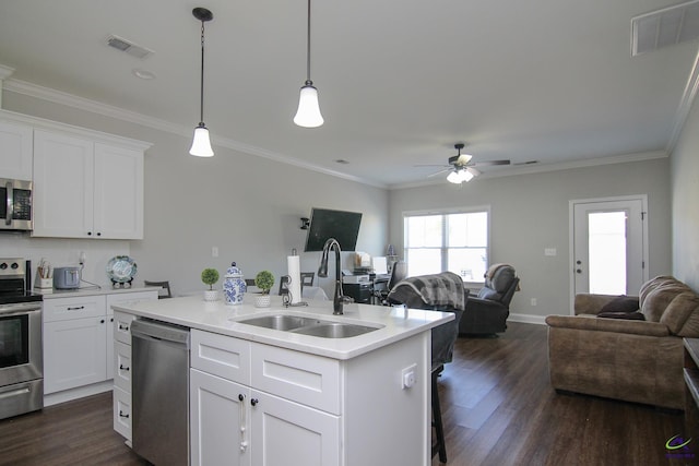 kitchen with ceiling fan, sink, white cabinetry, appliances with stainless steel finishes, and an island with sink