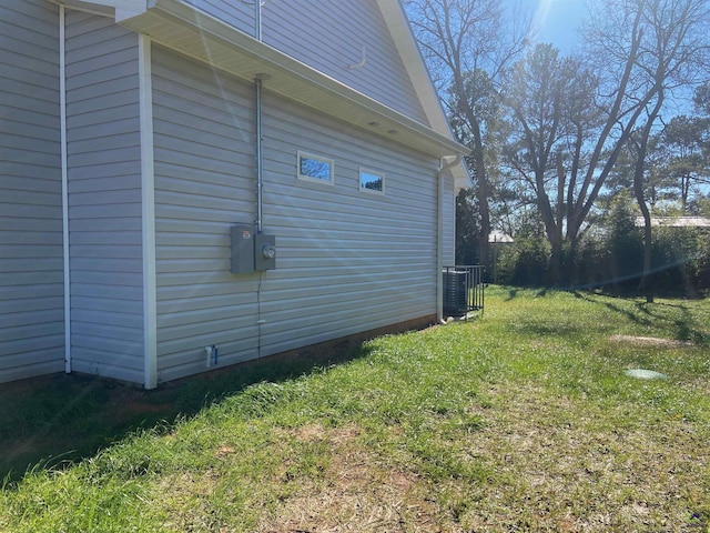 view of property exterior featuring central AC unit and a lawn