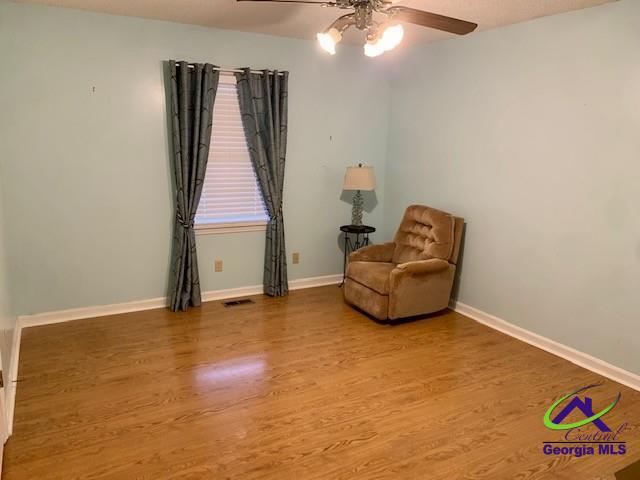 unfurnished room with ceiling fan and wood-type flooring