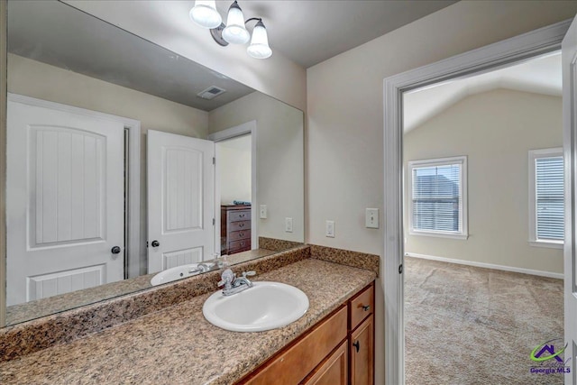 bathroom featuring vanity and lofted ceiling