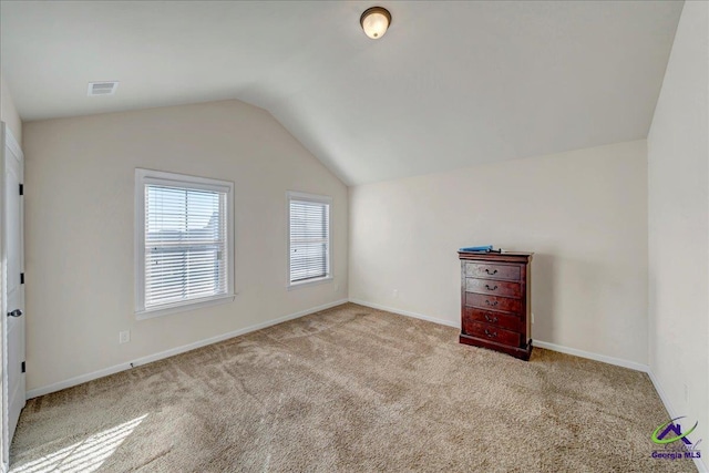 bonus room with light carpet and vaulted ceiling