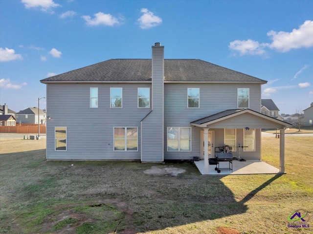 back of house with a lawn and a patio area