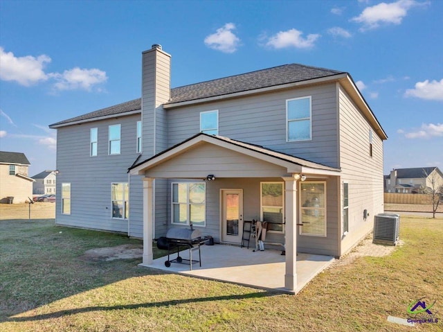 back of house with a patio area, a lawn, and central air condition unit