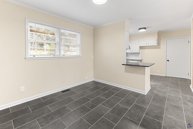 empty room featuring crown molding and dark tile patterned flooring