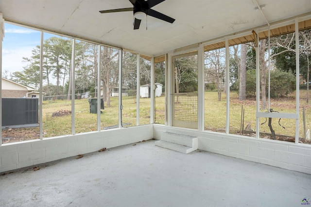 unfurnished sunroom with ceiling fan