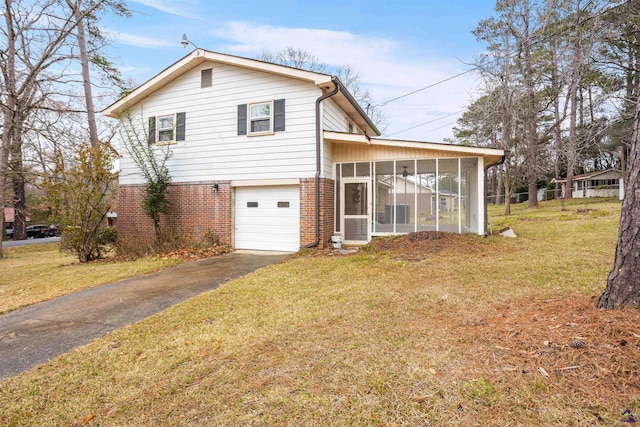 exterior space with a garage, a yard, and a sunroom