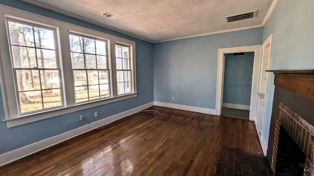 spare room with dark hardwood / wood-style flooring, ornamental molding, a textured ceiling, and a fireplace