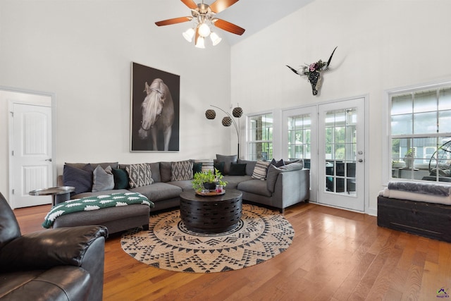 living room featuring hardwood / wood-style floors, a high ceiling, and ceiling fan