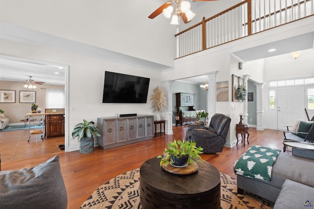 living room with decorative columns, a wealth of natural light, light hardwood / wood-style flooring, and ceiling fan