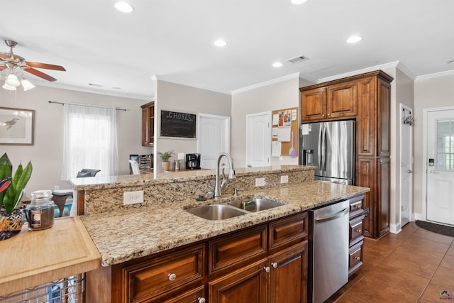 kitchen featuring dark tile patterned floors, light stone countertops, sink, ornamental molding, and stainless steel appliances