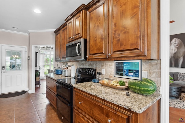 kitchen with decorative backsplash, range with two ovens, dark tile patterned floors, and crown molding