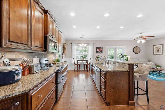 kitchen featuring crown molding, sink, decorative light fixtures, a kitchen bar, and stainless steel appliances