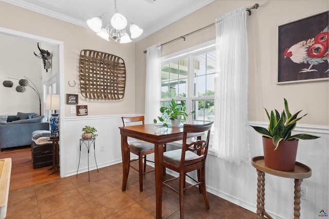 tiled dining room with a notable chandelier and crown molding