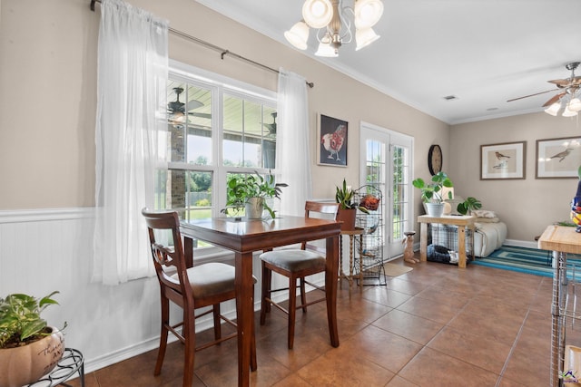 tiled dining area with ceiling fan with notable chandelier and ornamental molding