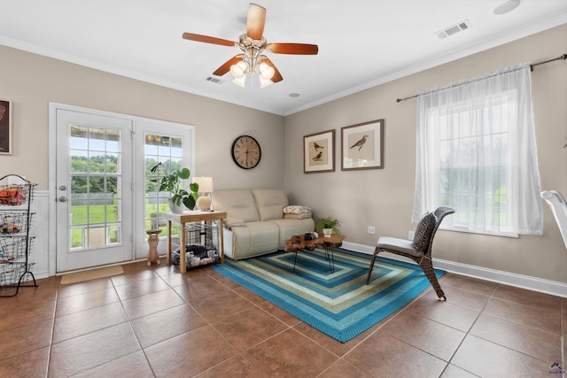 interior space with ceiling fan, dark tile patterned floors, and ornamental molding