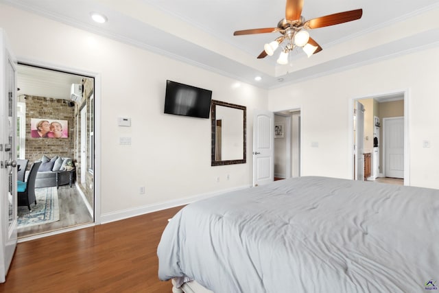 bedroom featuring ceiling fan, dark hardwood / wood-style floors, a tray ceiling, and crown molding