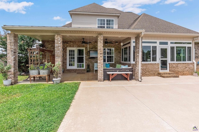 rear view of house featuring ceiling fan, a patio area, and a yard