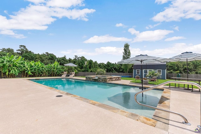 view of pool featuring an in ground hot tub, a patio area, and a shed