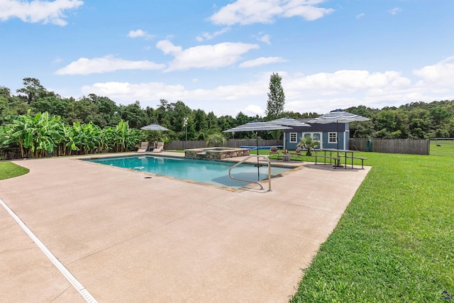 view of pool with an in ground hot tub, an outbuilding, a lawn, and a patio