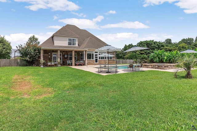 back of property with a fenced in pool, a yard, and a patio