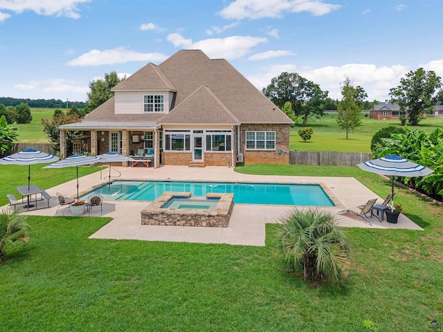 view of swimming pool with an in ground hot tub, a patio area, and a lawn