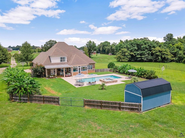 rear view of house featuring a patio area, a storage shed, a swimming pool with hot tub, and a yard