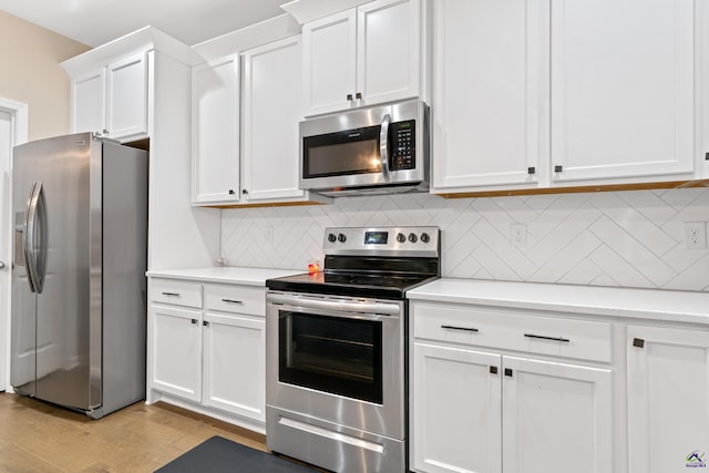 kitchen with white cabinetry, light hardwood / wood-style flooring, decorative backsplash, and stainless steel appliances